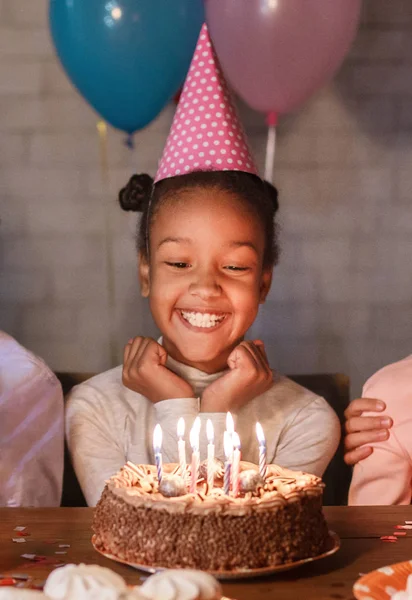 Szczęśliwa dziewczyna w party hat z tort urodzinowy — Zdjęcie stockowe