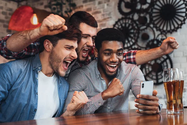 Чоловіки дивляться футбол на смартфон в барі — стокове фото