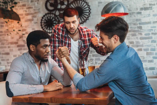 Diversos amigos divirtiéndose y tomando cerveza en el bar — Foto de Stock