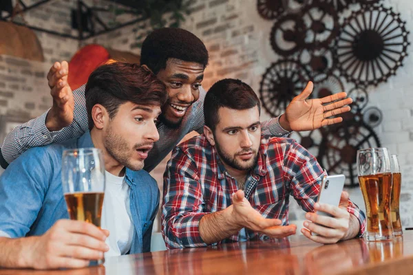 Hombres viendo los resultados del partido de fútbol en el teléfono inteligente — Foto de Stock