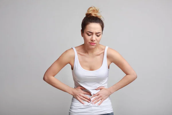 Mujer con dolor de estómago, intoxicación alimentaria, fondo gris —  Fotos de Stock