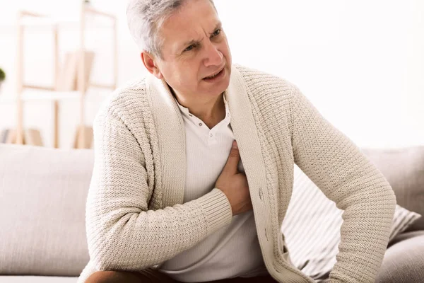 Reifer Mann mit Brustschmerzen, der einen Herzinfarkt erleidet — Stockfoto