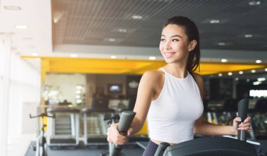 Eliptik eğitmen spor salonunda egzersiz kadın
