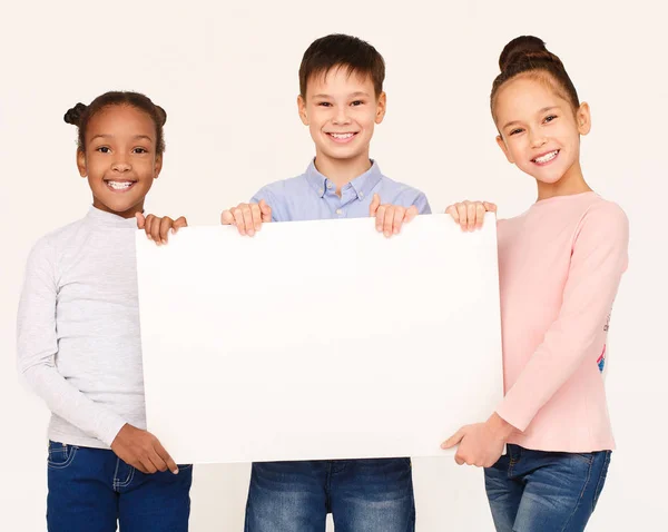 Crianças mostrando placa de cartaz em branco para texto — Fotografia de Stock