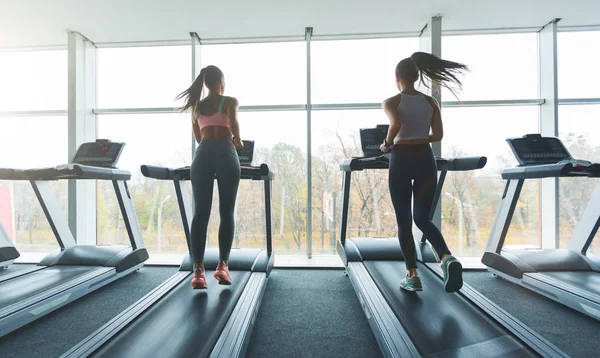 Sports people running on treadmills, looking out the window — Stock Photo, Image