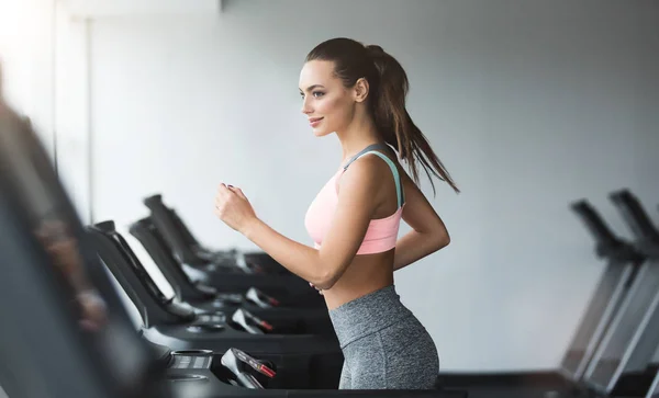 Spor kadın koşu bandı üzerinde kardiyo egzersizi yapıyor — Stok fotoğraf