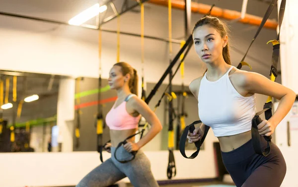 Meisjes trainen met Trx bandjes in sportschool — Stockfoto