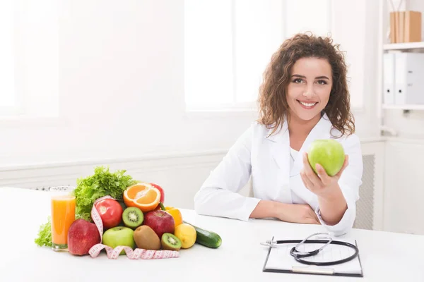 Nutritionniste femme offrant pomme verte à la caméra — Photo