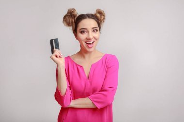 Kredi kartı arka plan üzerinde tutan mutlu kadın