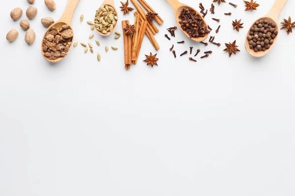 Cloves, anise stars, cinnamon sticks and nutmeg in spoons — Stock Photo, Image