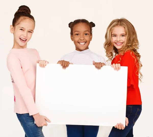 Chicas multiraciales sosteniendo pancarta en blanco para publicidad — Foto de Stock