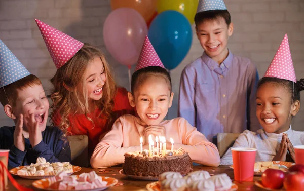 Crianças felizes olhando para bolo de aniversário com velas — Fotografia de Stock