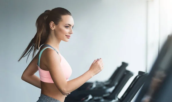 Frau beim Ausdauertraining auf Laufband im Fitnessstudio — Stockfoto