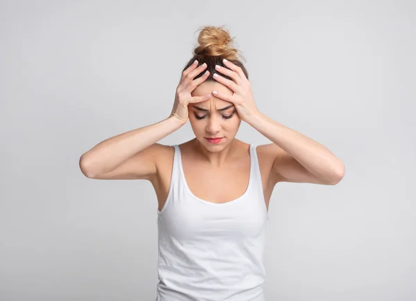 Yorgun kadın arka plan üzerinde dayanılmaz baş ağrısı acı — Stok fotoğraf
