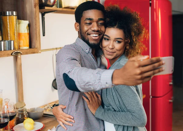 Afro-para biorąc selfie na smartfonie w kuchni — Zdjęcie stockowe