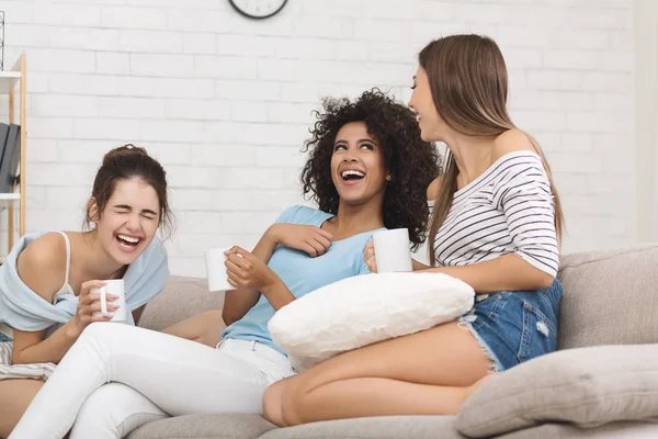 Namoradas rindo com piadas, bebendo café em casa — Fotografia de Stock