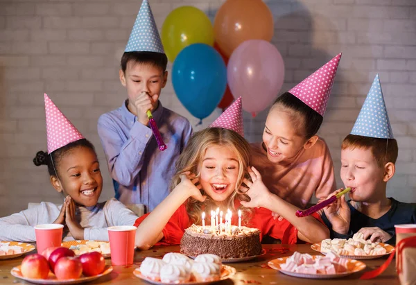 Дети смотрят на праздничный торт со свечами — стоковое фото
