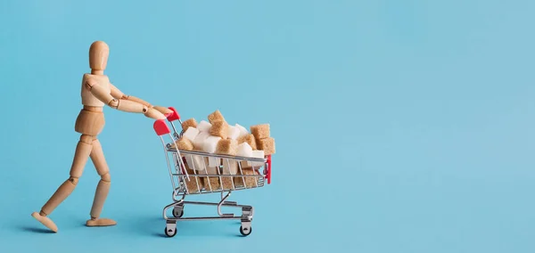 Winkelwagen met suikerklontjes op blauwe achtergrond — Stockfoto