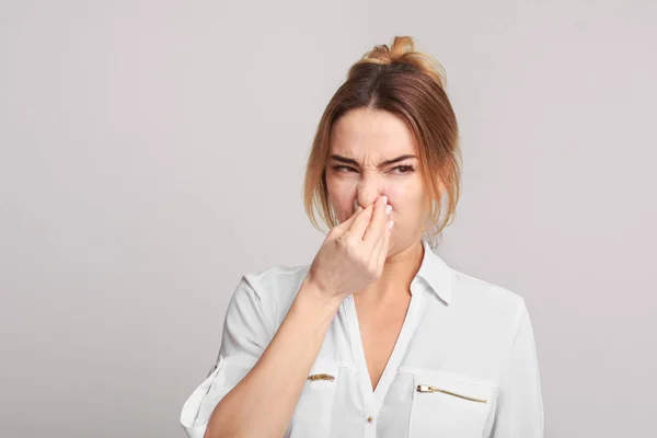 Vrouw neus sluiten vanwege de slechte geur — Stockfoto