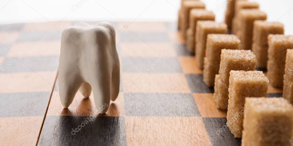 Healthy tooth against sugar army on chessboard