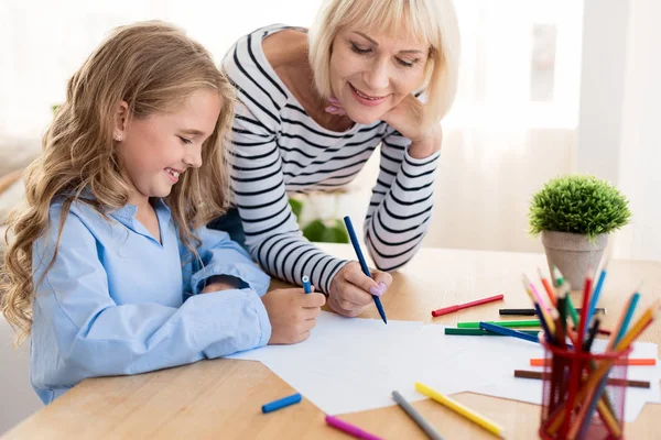 Büyükannesi ile birlikte evde çizim torunu