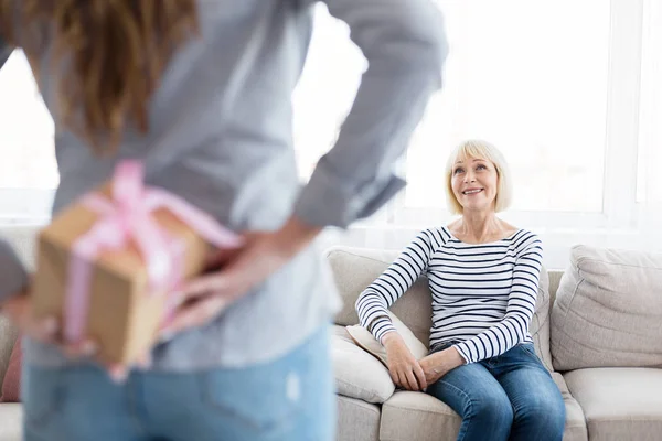 Woman hiding present for her mother at home — Stock Photo, Image