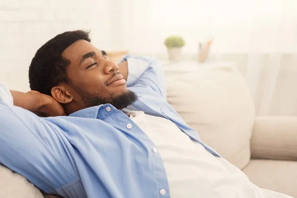 Handsome african-ameriacn man relaxing on sofa at home — Stock Photo, Image