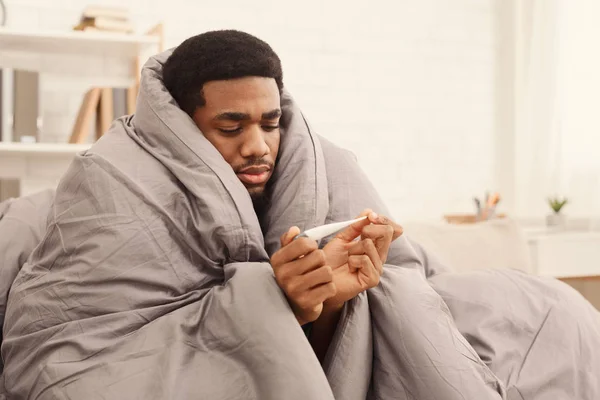 Άρρωστος άνθρωπος που καλύπτονται με κουβέρτα εκμετάλλευση θερμόμετρο — Φωτογραφία Αρχείου
