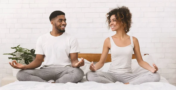 Jovem família negra meditando na cama juntos — Fotografia de Stock