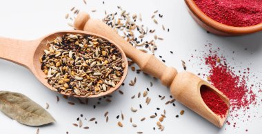 Tahta kaşık ve beyaz arka plan üzerinde kepçe sumak karışık baharat