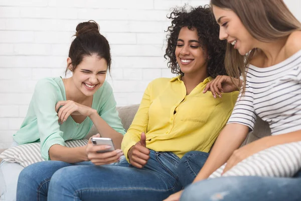 Vrouw grappig inhoud weergeeft op smartphone aan vrienden — Stockfoto