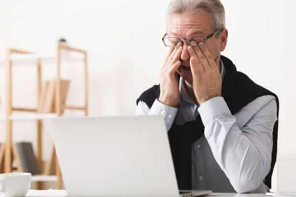 Giornata difficile. Uomo anziano sensazione di stanchezza, lavorando sul computer portatile — Foto Stock