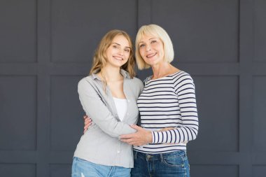 Mutlu anne ve kızı kucaklayan, kameraya bakıyor