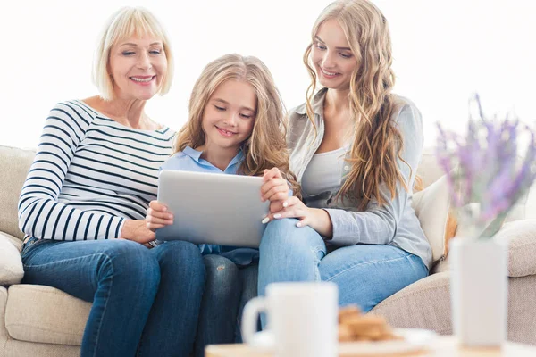 Tablet bilgisayarınızda evde kanepe ile aile — Stok fotoğraf