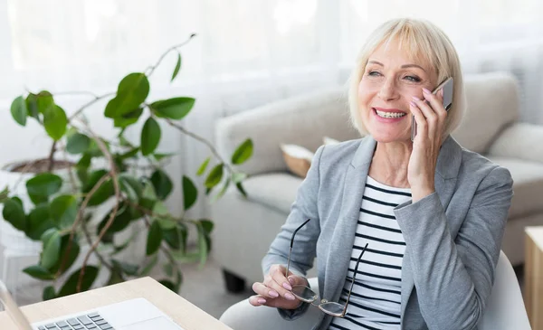 Senior zakenvrouw praten over telefoon, raadpleging van klanten — Stockfoto