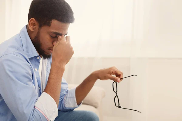 Cansado negro millennial hombre masajeando nariz puente — Foto de Stock