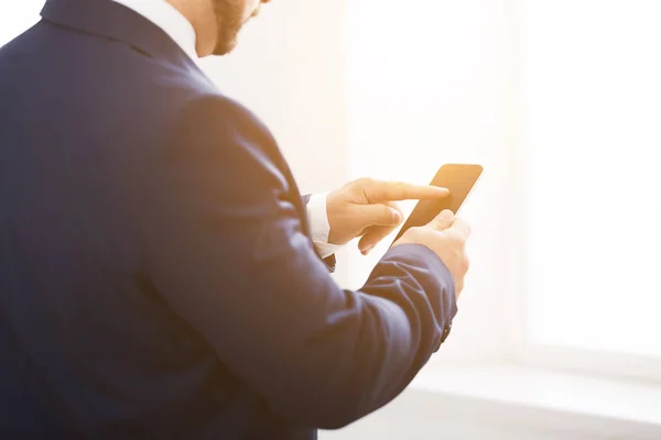 Selbstbewusster junger Mann textet im Büro auf Smartphone — Stockfoto