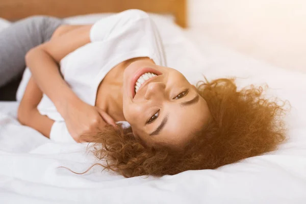 Chica afroamericana acostada en la cama por la mañana —  Fotos de Stock