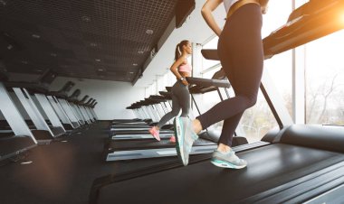 Güneşli günde koşu bandı üzerinde çalışan sporcu