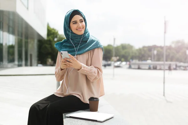 Mahasiswa perempuan muslim mengenakan jilbab di latar belakang perkotaan — Stok Foto