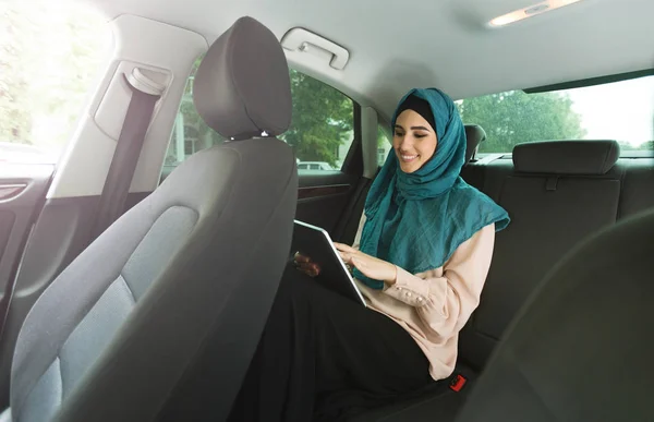 Islamitische dame met Tablet PC in de auto — Stockfoto