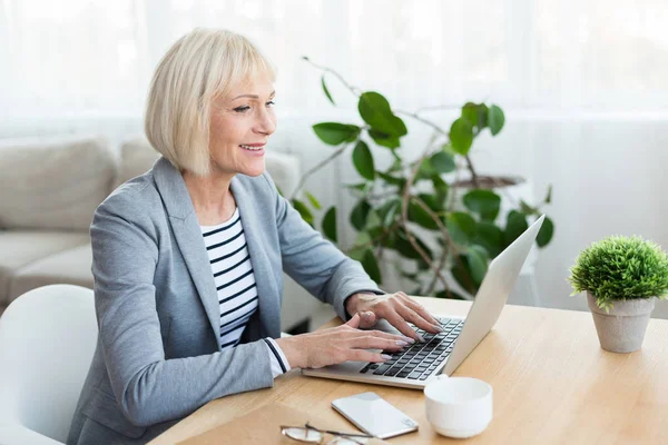 Senior vrouw werkt op laptop computer thuis — Stockfoto