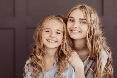 Sarılma ve kameraya bakarak mutlu kardeşler