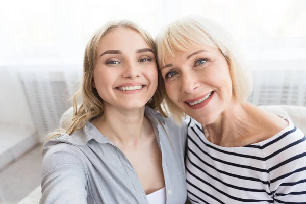 Mãe e filha sênior tomando selfie em casa — Fotografia de Stock