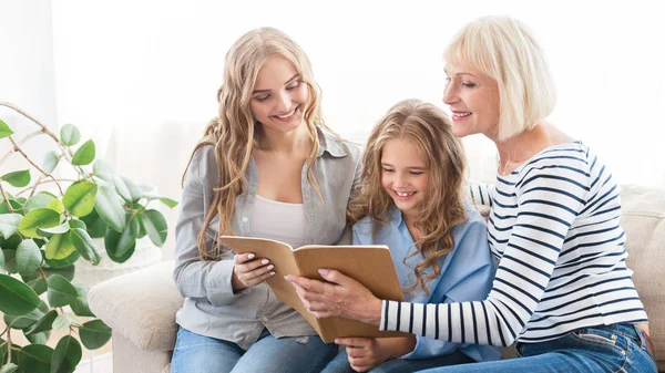 Mormor, mor och dotter titta på albumet hemma — Stockfoto