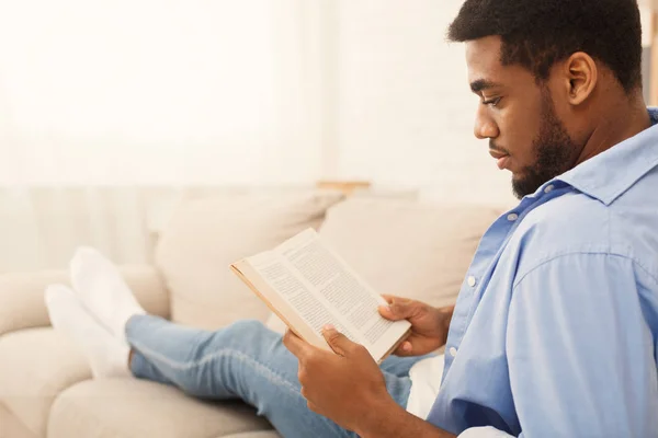 Schwarzer männlicher Student liest Buch zu Hause — Stockfoto