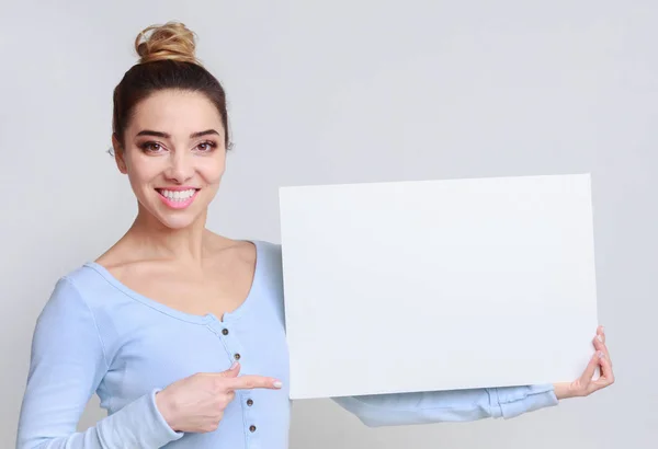 Счастливая женщина с доской для копирования для рекламы — стоковое фото