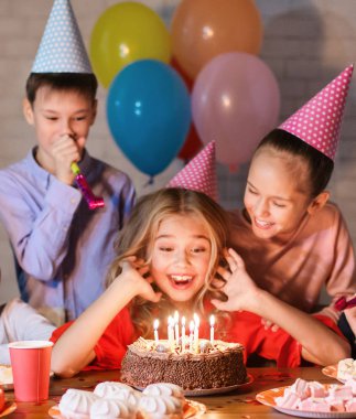 Doğum günü pastası ile parti şapkalı mutlu kız