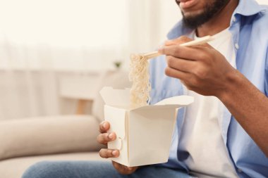 Genç Afro-Amerikan adam evde Asya yemek yeme