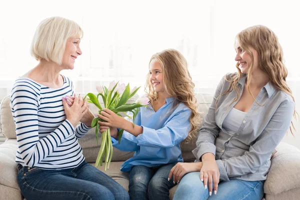 Schattig meisje bloemen geven aan haar grootmoeder — Stockfoto